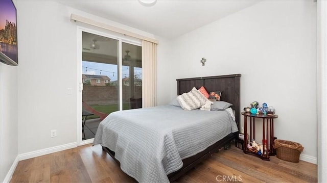 bedroom with access to exterior, wood finished floors, and baseboards