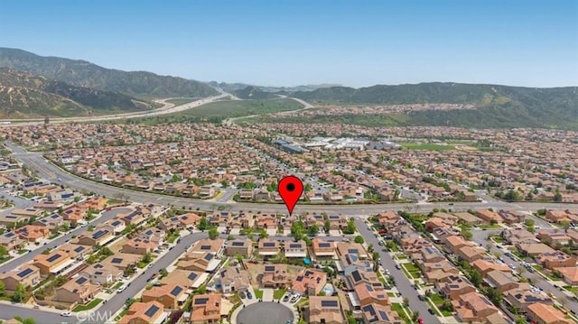 aerial view of property's location featuring a mountainous background and nearby suburban area