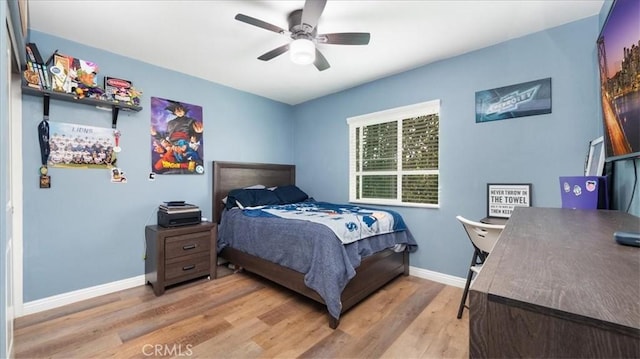 bedroom featuring light wood-style flooring, baseboards, and a ceiling fan