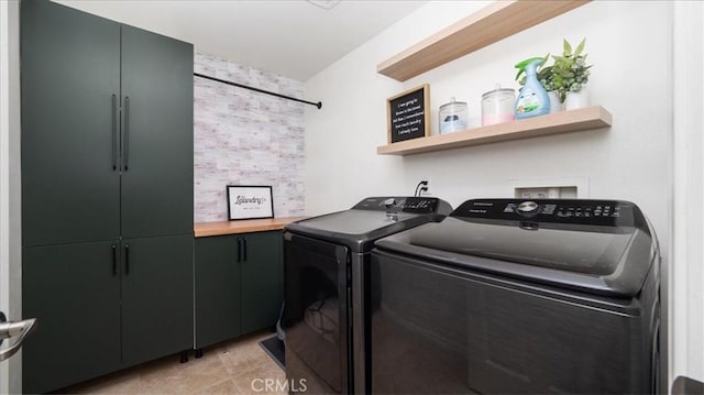 laundry area with washer and dryer, cabinet space, and light tile patterned floors