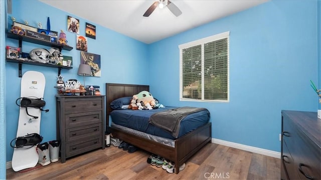 bedroom with wood finished floors, baseboards, and ceiling fan