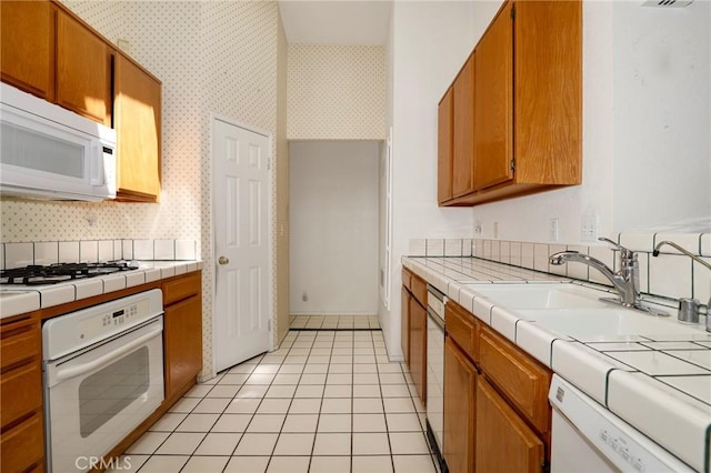 4102 Victoria Ln, Quartz Hill, CA 93536 - kitchen featuring white appliances, tile countertops, light tile patterned flooring, decorative backsplash, and wallpapered walls