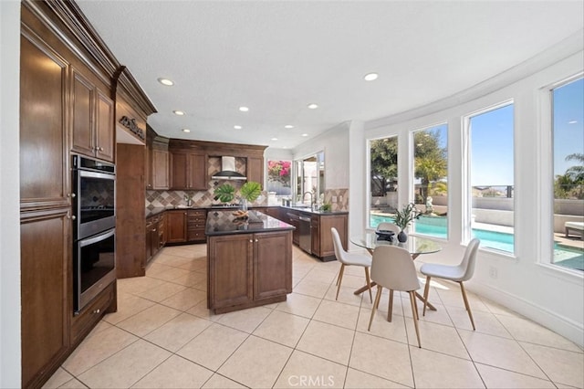 23721 Via Segovia, Murrieta, CA 92562 - kitchen featuring appliances with stainless steel finishes, ornamental molding, wall chimney range hood, dark countertops, and decorative backsplash
