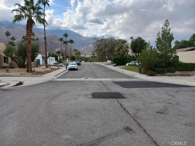 1123 E El Cid E, El Cid, Palm Springs, CA 92262 - view of asphalt street featuring a mountain view, sidewalks, and curbs