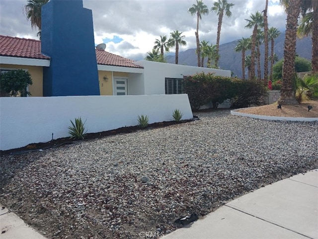 1123 E El Cid E, El Cid, Palm Springs, CA 92262 - view of side of home featuring a fenced front yard, stucco siding, and a tiled roof