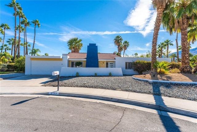 1123 E El Cid E, El Cid, Palm Springs, CA 92262 - mediterranean / spanish-style home featuring stucco siding, a tile roof, concrete driveway, an attached garage, and a chimney