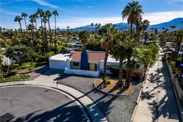 1123 E El Cid E, El Cid, Palm Springs, CA 92262 - view of front of house featuring a mountain view, a tiled roof, concrete driveway, and stucco siding