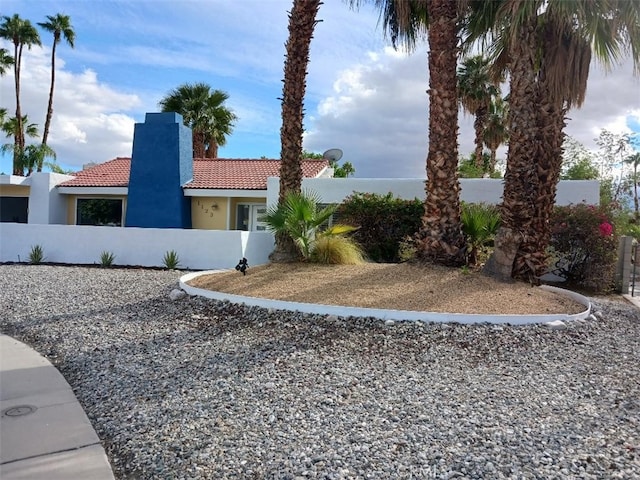 1123 E El Cid E, El Cid, Palm Springs, CA 92262 - view of front facade with a tile roof, a chimney, and stucco siding