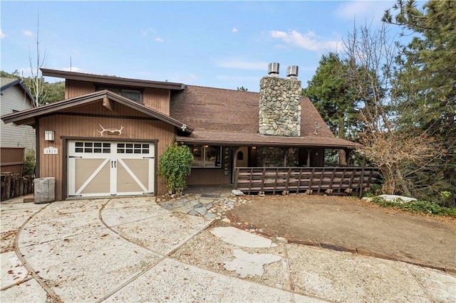 1513 Bernina Dr, Pine Mountain Club, CA 93222 - view of front of property with concrete driveway, a chimney, covered porch, a garage, and roof with shingles