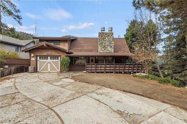 1513 Bernina Dr, Pine Mountain Club, CA 93222 - view of front facade with driveway, a chimney, a garage, and fence
