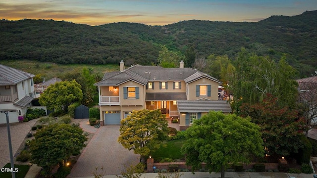 181 Via Sandra, Newbury Park, CA 91320 - view of front facade with a chimney, a balcony, a garage, decorative driveway, and a mountain view