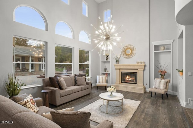 181 Via Sandra, Newbury Park, CA 91320 - living room featuring a towering ceiling, built in features, wood finished floors, a glass covered fireplace, and a chandelier