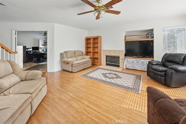 28652 Deer Springs Dr, Saugus, CA 91390 - living room with a ceiling fan, wood finished floors, a tile fireplace, and stairs