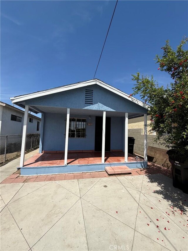 8711 Beach St, Los Angeles, CA 90002 - rear view of house featuring stucco siding, fence, and covered porch