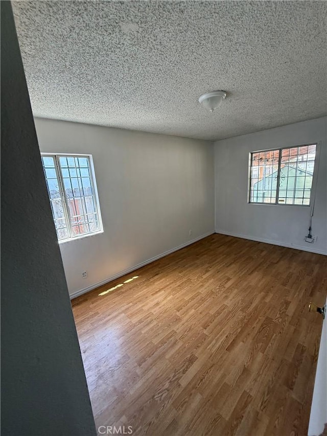 8711 Beach St, Los Angeles, CA 90002 - unfurnished room with a textured ceiling, wood finished floors, and baseboards