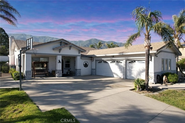 12798 N Rim Way, Rancho Cucamonga, CA 91739 - ranch-style house with a garage, driveway, a mountain view, stone siding, and stucco siding