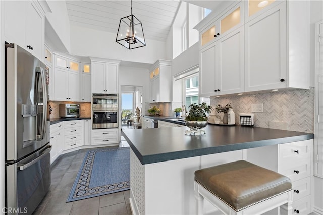 45 Northampton Ct, Newport Beach, CA 92660 - kitchen with appliances with stainless steel finishes, a peninsula, dark countertops, tasteful backsplash, and tile patterned flooring