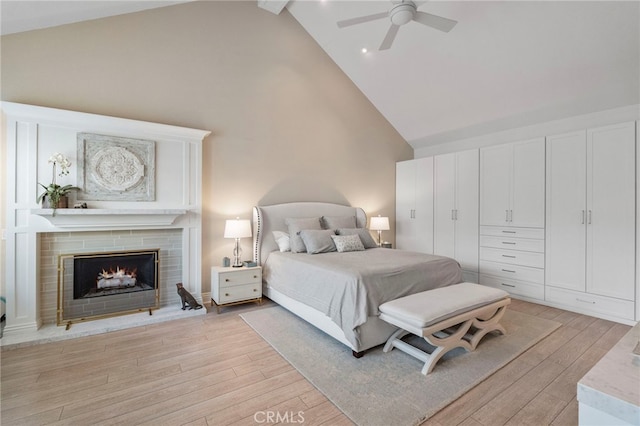 45 Northampton Ct, Newport Beach, CA 92660 - bedroom with high vaulted ceiling, light wood-type flooring, a warm lit fireplace, a ceiling fan, and beam ceiling
