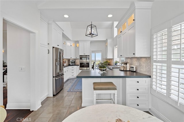45 Northampton Ct, Newport Beach, CA 92660 - kitchen featuring appliances with stainless steel finishes, decorative backsplash, white cabinets, a peninsula, and dark countertops