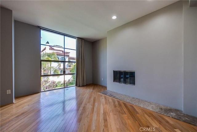 143 Union Jack Mall, Marina Del Rey, CA 90292 - unfurnished living room featuring floor to ceiling windows, light wood-style floors, a glass covered fireplace, and recessed lighting