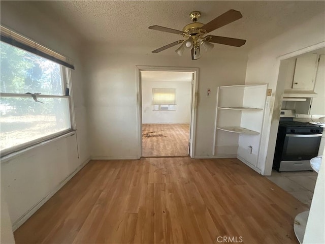 4004 N 3rd Ave, San Bernardino, CA 92407 - unfurnished dining area featuring ceiling fan, light wood-style flooring, and a textured ceiling