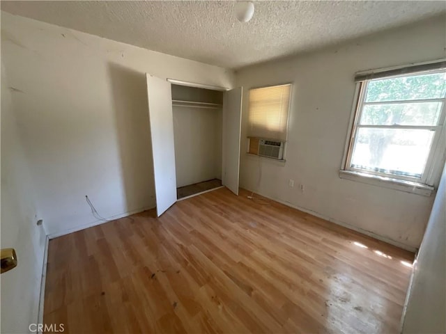4004 N 3rd Ave, San Bernardino, CA 92407 - unfurnished bedroom featuring light wood-style flooring, cooling unit, a textured ceiling, and a closet