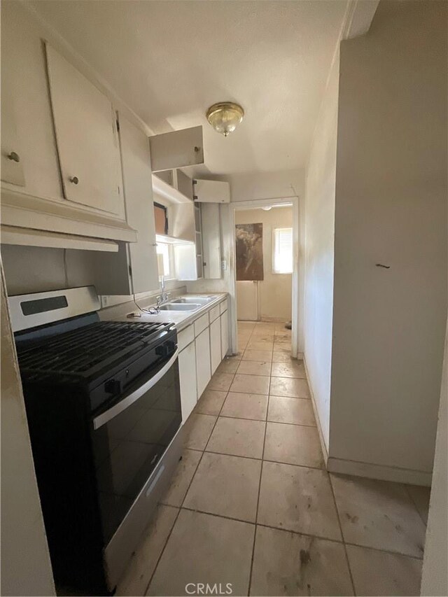 4004 N 3rd Ave, San Bernardino, CA 92407 - kitchen with gas range, white cabinets, light tile patterned floors, and light countertops