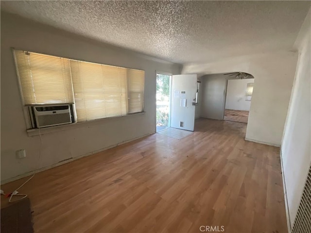 4004 N 3rd Ave, San Bernardino, CA 92407 - spare room with light wood-style floors, a textured ceiling, arched walkways, and cooling unit