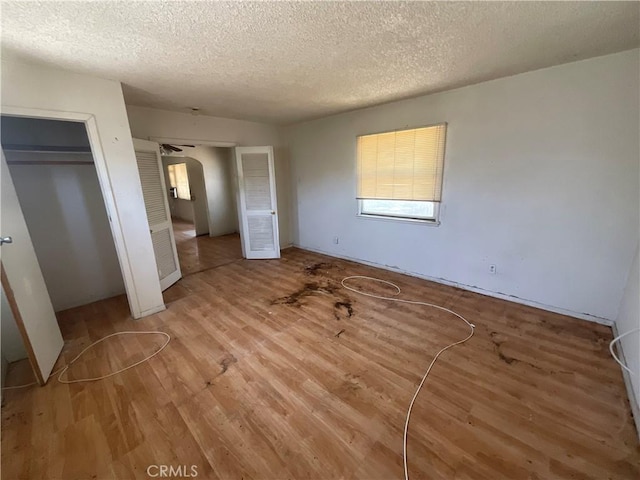 4004 N 3rd Ave, San Bernardino, CA 92407 - unfurnished bedroom with wood finished floors, a textured ceiling, and multiple closets