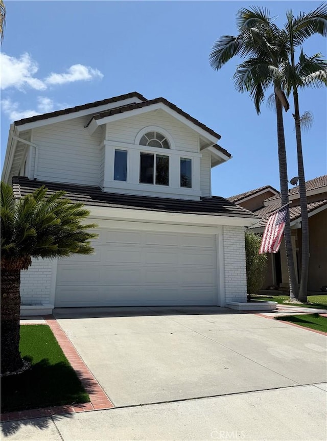 view of front of house with a garage, concrete driveway, and brick siding