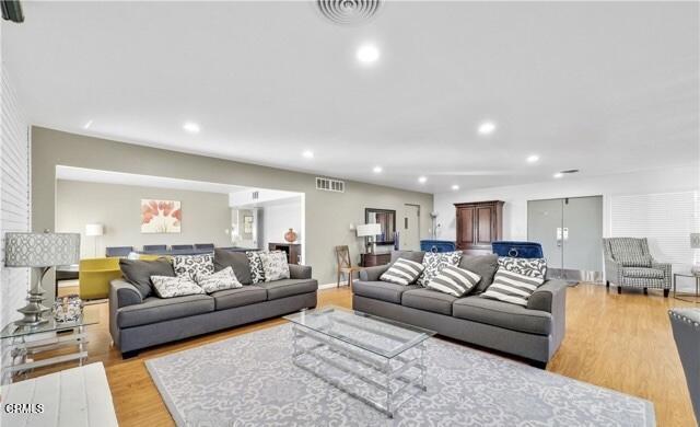 living area featuring light wood-style flooring and recessed lighting