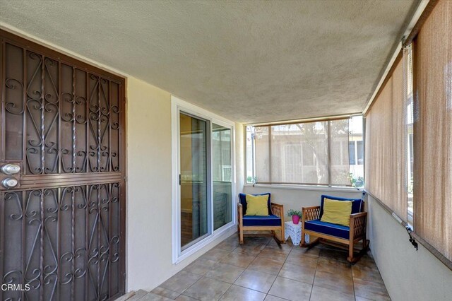 sunroom with a textured ceiling and tile patterned flooring