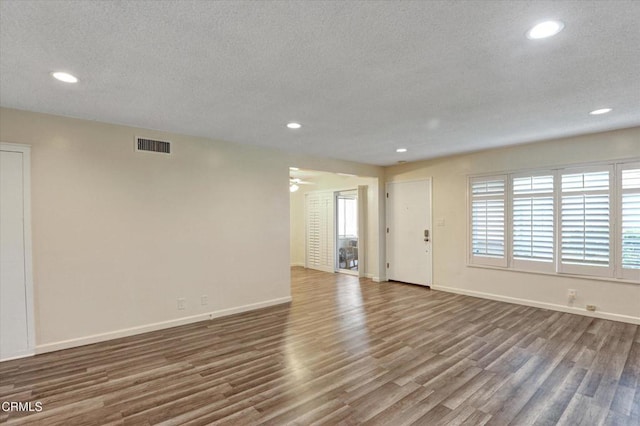 unfurnished living room featuring wood finished floors, recessed lighting, baseboards, a textured ceiling, and a ceiling fan