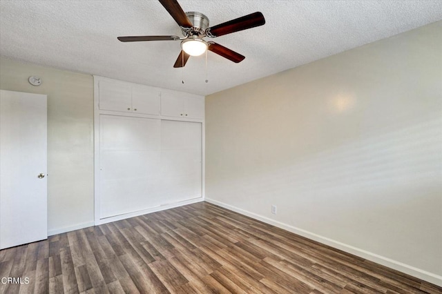 unfurnished bedroom featuring wood finished floors, a closet, baseboards, a textured ceiling, and a ceiling fan