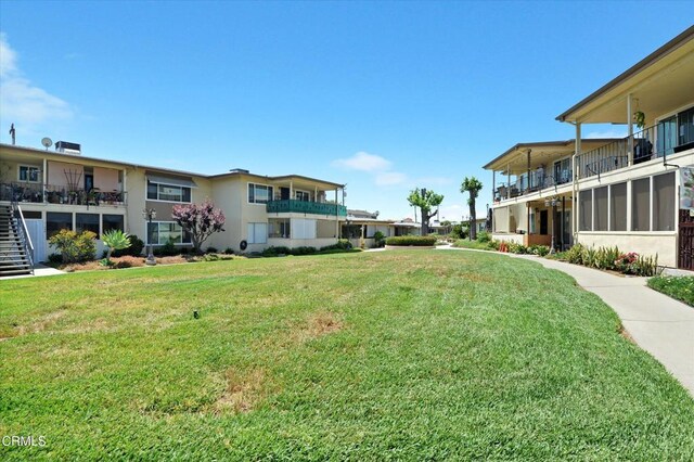 view of grassy yard with stairs