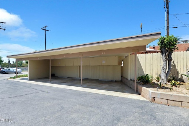 covered parking lot featuring fence