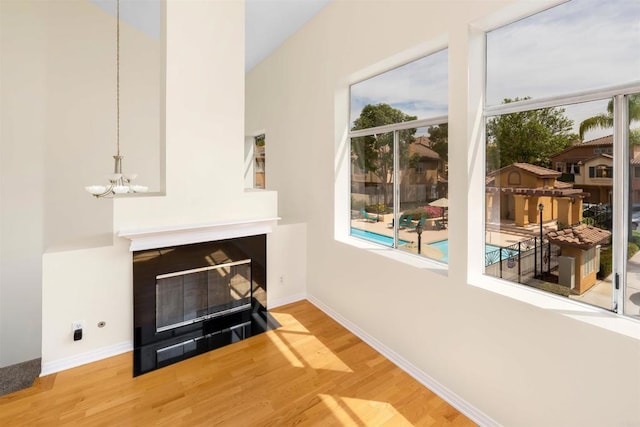 11354 Via Rancho San Diego Unit J, El Cajon, CA 92019 - living area with wood finished floors, a chandelier, a fireplace with flush hearth, and baseboards