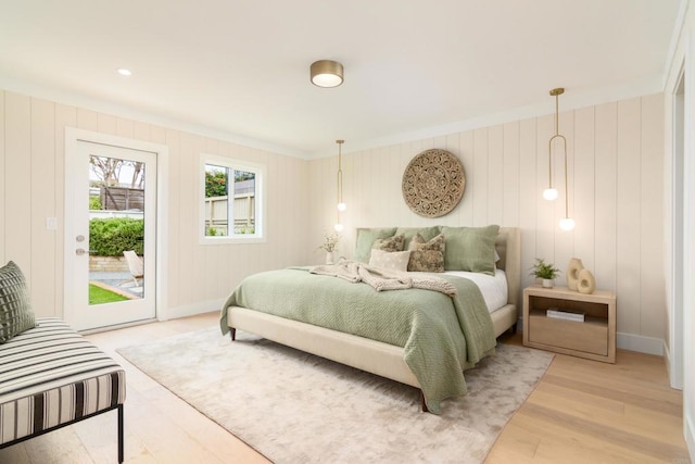 bedroom featuring access to outside, light wood-type flooring, crown molding, and baseboards