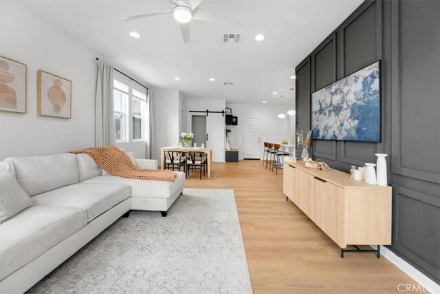 10243 Graphite St, Spring Valley, CA 91977 - living room with a barn door, ceiling fan, light wood-style flooring, and recessed lighting