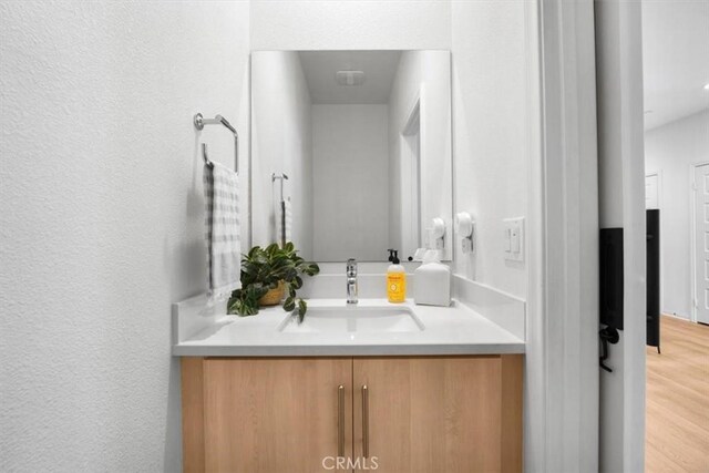 10243 Graphite St, Spring Valley, CA 91977 - bathroom featuring vanity, wood finished floors, and a textured wall