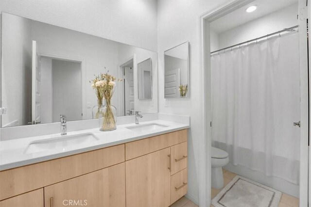 10243 Graphite St, Spring Valley, CA 91977 - full bath with tile patterned flooring, toilet, double vanity, and shower / tub combo with curtain