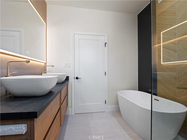 3810 Locke Ave, Los Angeles, CA 90032 - bathroom featuring a soaking tub, double vanity, tile patterned flooring, and baseboards