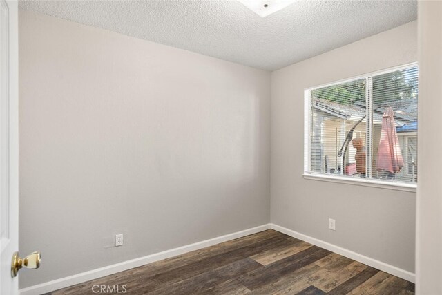 1256 Warner St, Chico, CA 95926 - unfurnished room featuring dark wood-style floors, a textured ceiling, and baseboards