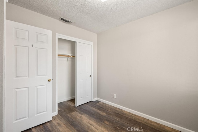 1256 Warner St, Chico, CA 95926 - unfurnished bedroom featuring dark wood finished floors, baseboards, a closet, and a textured ceiling