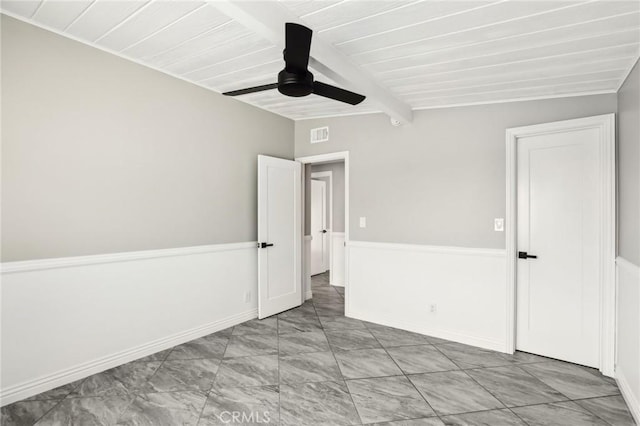 spare room featuring ceiling fan and beamed ceiling