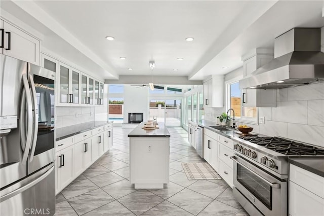 2105 Noble View Dr, Rancho Palos Verdes, CA 90275 - kitchen with stainless steel appliances, a sink, wall chimney range hood, a ceiling fan, and decorative backsplash
