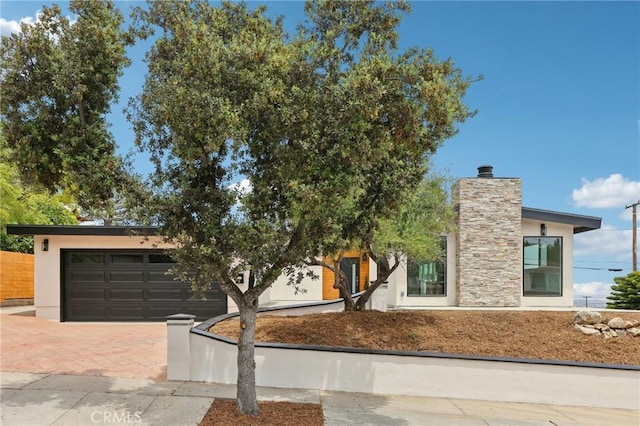 2105 Noble View Dr, Rancho Palos Verdes, CA 90275 - view of front facade with decorative driveway, stucco siding, an attached garage, and a chimney