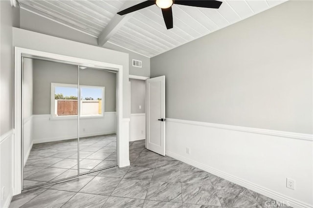 unfurnished bedroom featuring marble look tile flooring, a closet, and a ceiling fan