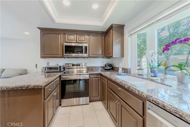 5855 Via Sonora Unit 39, Yorba Linda, CA 92887 - kitchen with stainless steel appliances, a sink, a raised ceiling, light tile patterned floors, and light stone countertops