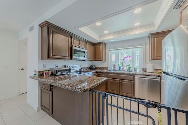 5855 Via Sonora Unit 39, Yorba Linda, CA 92887 - kitchen featuring stainless steel appliances, a raised ceiling, a sink, ornamental molding, and a peninsula
